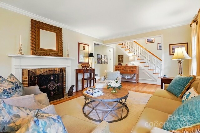 2025 Sagamore Rd, Charlotte, NC 28209 - living room featuring stairs, crown molding, wood finished floors, and a fireplace