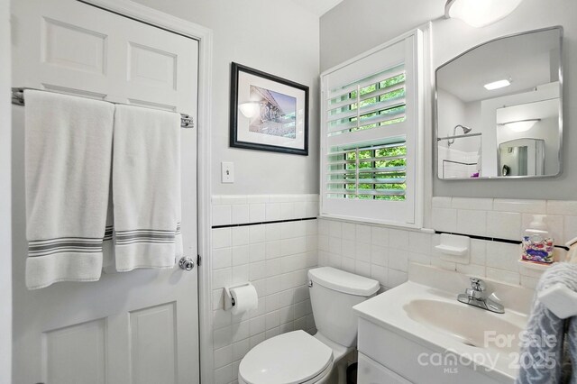 2025 Sagamore Rd, Charlotte, NC 28209 - bathroom featuring tile walls, toilet, wainscoting, and vanity