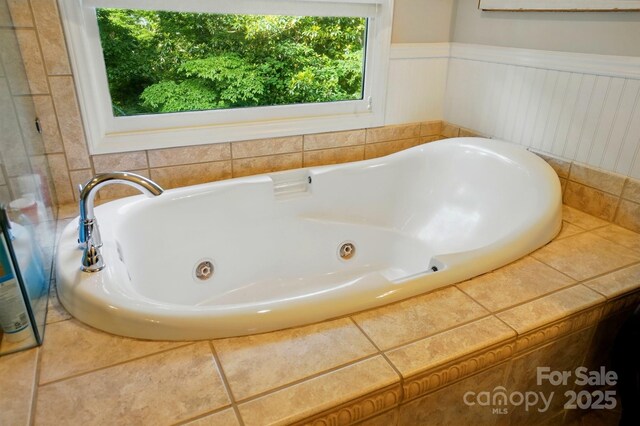 2025 Sagamore Rd, Charlotte, NC 28209 - bathroom featuring a jetted tub and a wainscoted wall