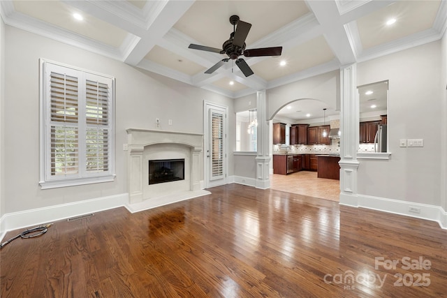 310 Ridge Reserve Dr, Clover, SC 29710 - unfurnished living room featuring ornate columns, coffered ceiling, arched walkways, a ceiling fan, and wood finished floors