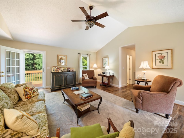 living room featuring wood finished floors, ceiling fan, lofted ceiling, and baseboards