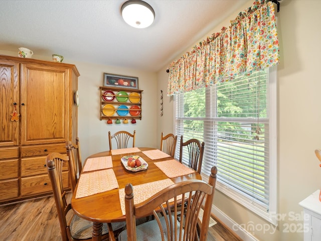 dining area with light wood-type flooring and baseboards