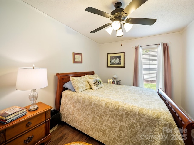 bedroom featuring dark wood finished floors, vaulted ceiling, a ceiling fan, and ornamental molding