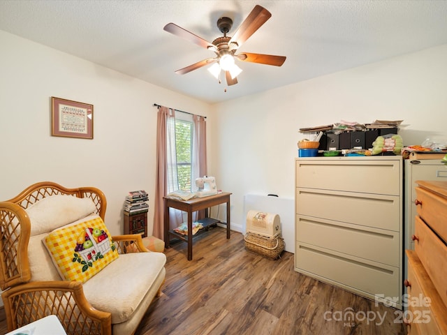 sitting room with wood finished floors and a ceiling fan