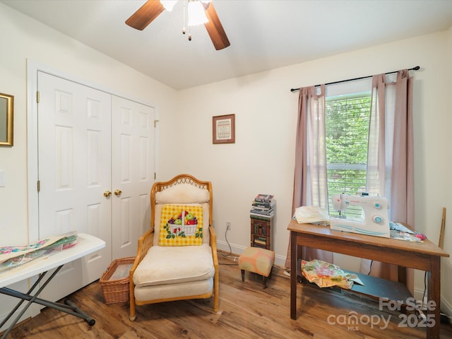 sitting room featuring wood finished floors, ceiling fan, and baseboards