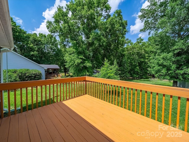 deck featuring a yard and view of scattered trees