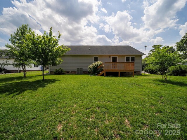rear view of house featuring crawl space, a deck, a lawn, and central AC