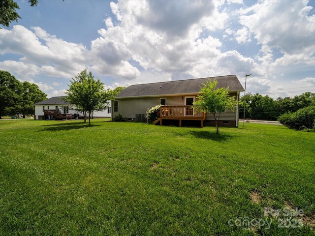 rear view of property with crawl space, a deck, a lawn, and cooling unit