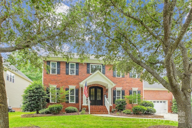8612 Tintinhull Ln, Waxhaw, NC 28173 - view of front facade with french doors, brick siding, a front yard, and a garage