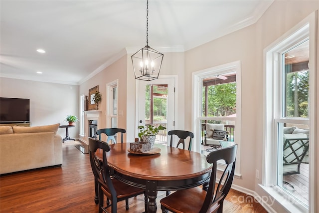8612 Tintinhull Ln, Waxhaw, NC 28173 - dining area with ornamental molding, dark wood-type flooring, a chandelier, a glass covered fireplace, and recessed lighting