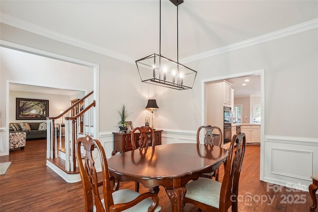 8612 Tintinhull Ln, Waxhaw, NC 28173 - dining space featuring ornamental molding, dark wood-style flooring, a decorative wall, wainscoting, and a chandelier