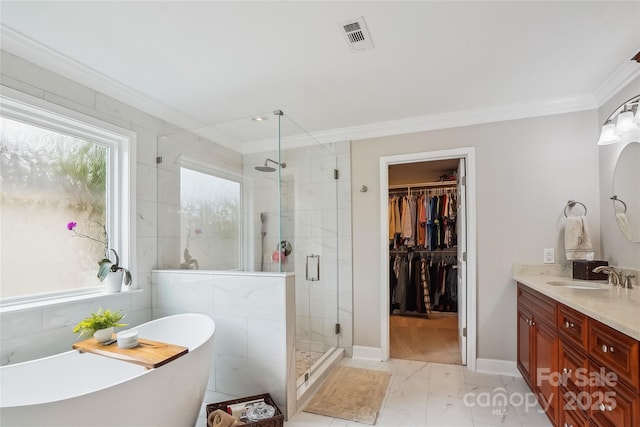 8612 Tintinhull Ln, Waxhaw, NC 28173 - bathroom featuring ornamental molding, marble finish floors, double vanity, a freestanding tub, and a shower stall