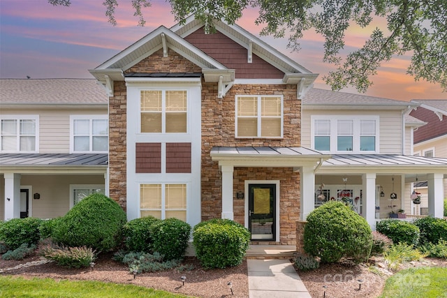 2324 Bonterra Blvd, Indian Trail, NC 28079 - view of front of property with a standing seam roof, stone siding, a porch, roof with shingles, and metal roof