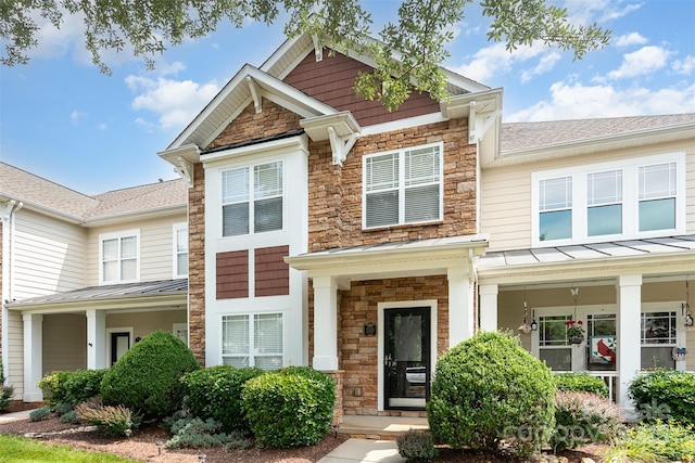 2324 Bonterra Blvd, Indian Trail, NC 28079 - view of front of property featuring stone siding, a standing seam roof, metal roof, a shingled roof, and covered porch