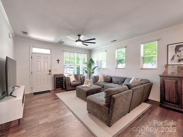 living room with dark wood finished floors, crown molding, ceiling fan, and baseboards