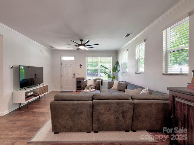 living room featuring dark wood-style floors, crown molding, baseboards, and a ceiling fan