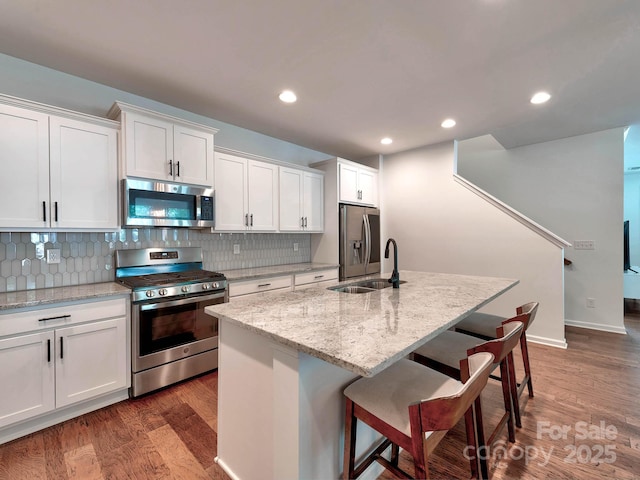 kitchen featuring appliances with stainless steel finishes, white cabinets, decorative backsplash, and recessed lighting