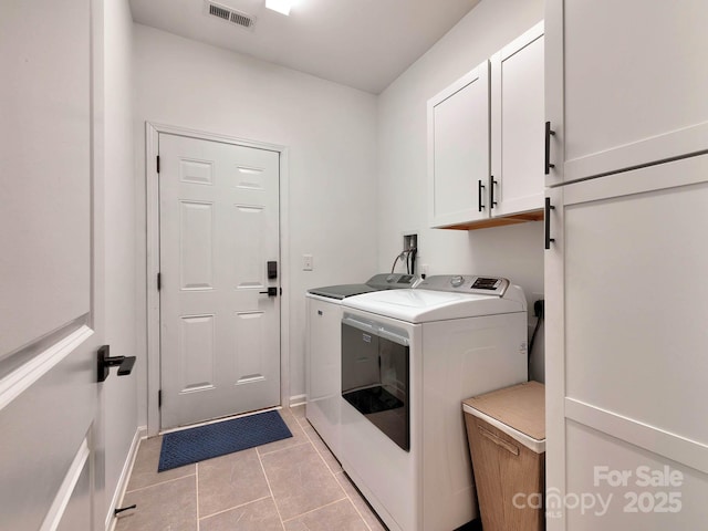 laundry area with cabinet space, washer and clothes dryer, light tile patterned floors, and baseboards