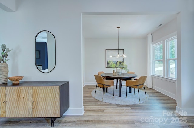 1025 Harrogate Dr, Bessemer City, NC 28016 - dining space featuring wood finished floors, baseboards, and a chandelier