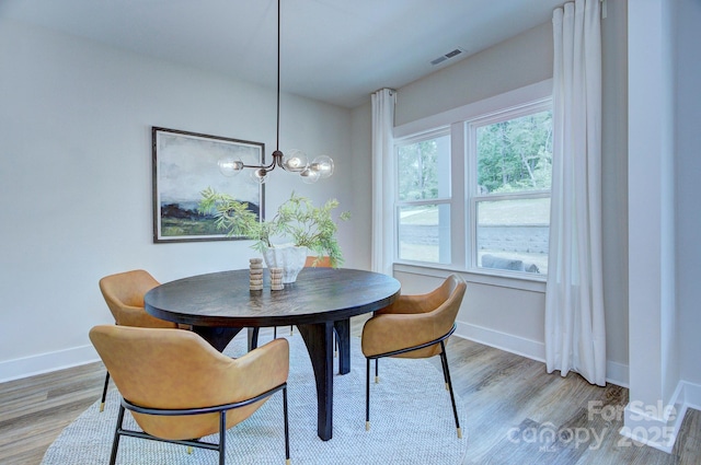 1025 Harrogate Dr, Bessemer City, NC 28016 - dining space with baseboards, light wood-type flooring, and a chandelier