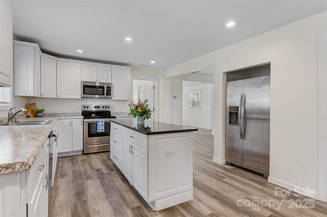 25 Southern Way, Nebo, NC 28761 - kitchen with appliances with stainless steel finishes, a sink, white cabinets, light wood-style flooring, and recessed lighting