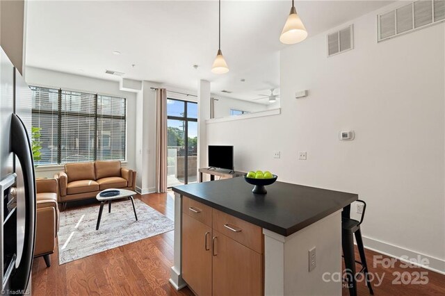 810 W 4th St Unit 201, Winston Salem, NC 27101 - kitchen featuring stainless steel refrigerator with ice dispenser, dark countertops, open floor plan, and a center island