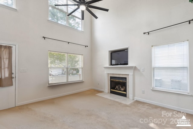 1457 Matthew Allen Cir, Kannapolis, NC 28081 - unfurnished living room featuring carpet floors, a tile fireplace, a ceiling fan, a towering ceiling, and plenty of natural light