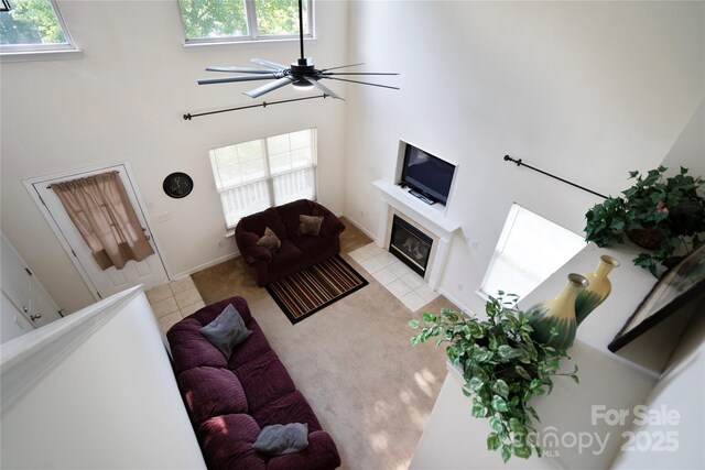 1457 Matthew Allen Cir, Kannapolis, NC 28081 - living room featuring a fireplace, a towering ceiling, a ceiling fan, and light tile patterned flooring