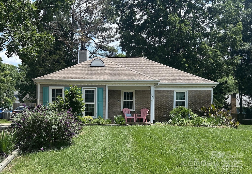 7607 Swedish Ivy Ln, Charlotte, NC 28227 - back of property with a lawn, a chimney, brick siding, and a shingled roof