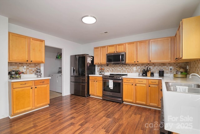 8511 Redding Glen Ave, Charlotte, NC 28216 - kitchen with appliances with stainless steel finishes, washer and clothes dryer, a sink, backsplash, and dark wood finished floors