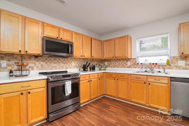 8511 Redding Glen Ave, Charlotte, NC 28216 - kitchen featuring appliances with stainless steel finishes, a sink, light countertops, dark wood-type flooring, and tasteful backsplash
