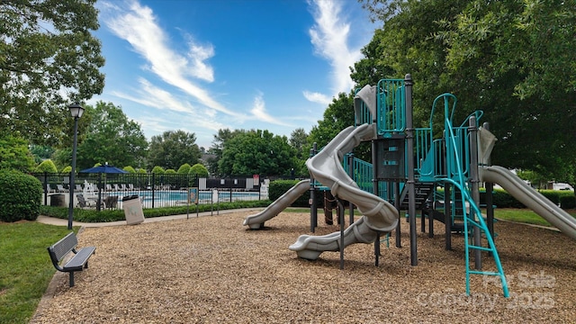 8511 Redding Glen Ave, Charlotte, NC 28216 - community jungle gym featuring fence, a community pool, and view of wooded area