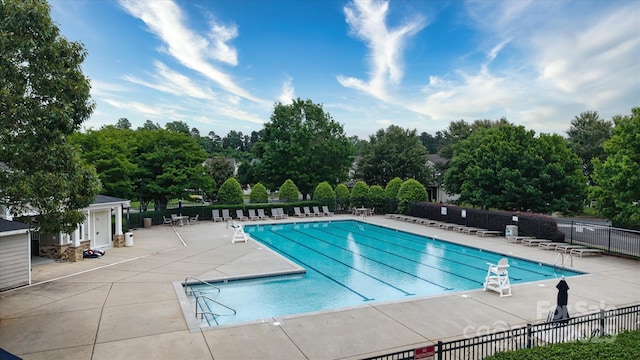 8511 Redding Glen Ave, Charlotte, NC 28216 - community pool with fence, a patio area, and view of scattered trees
