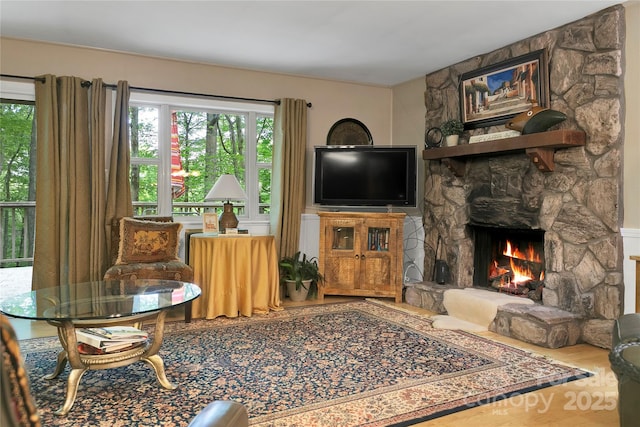 living area featuring plenty of natural light, a fireplace, and wood finished floors