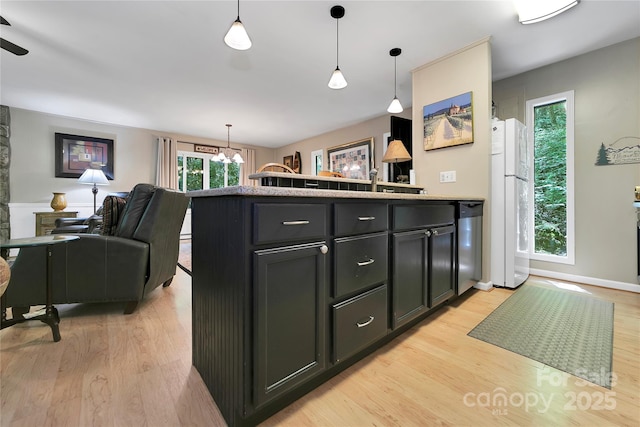 kitchen with freestanding refrigerator, a chandelier, light wood finished floors, and hanging light fixtures