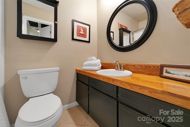 bathroom featuring vanity, tile patterned floors, toilet, and baseboards
