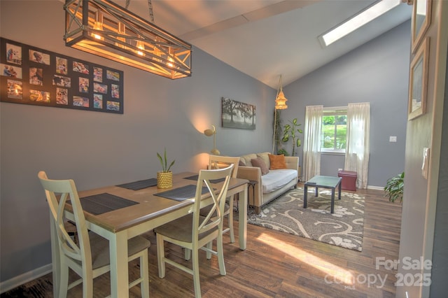 5995 Tall Tree Ln, Harrisburg, NC 28075 - dining room featuring wood finished floors, baseboards, high vaulted ceiling, and a chandelier