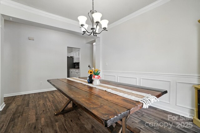 2426 Tory Oak Pl, Matthews, NC 28105 - dining space with dark wood-style flooring, ornamental molding, a chandelier, wainscoting, and a decorative wall