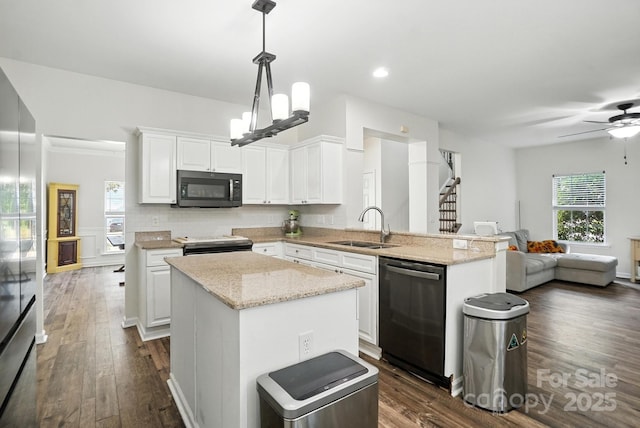 2426 Tory Oak Pl, Matthews, NC 28105 - kitchen with black microwave, dishwashing machine, a peninsula, white cabinetry, and electric range oven
