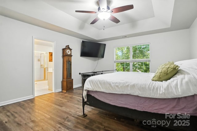 2426 Tory Oak Pl, Matthews, NC 28105 - bedroom featuring a raised ceiling, wood finished floors, ensuite bathroom, and a ceiling fan