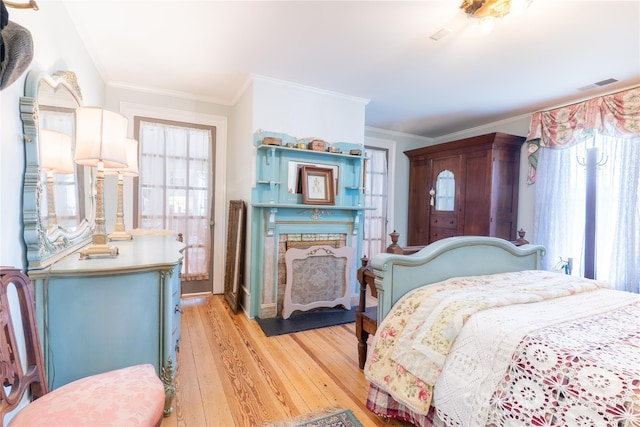 131 E Lexington Rd, Mocksville, NC 27028 - bedroom with multiple windows, light wood-type flooring, a fireplace with flush hearth, and crown molding