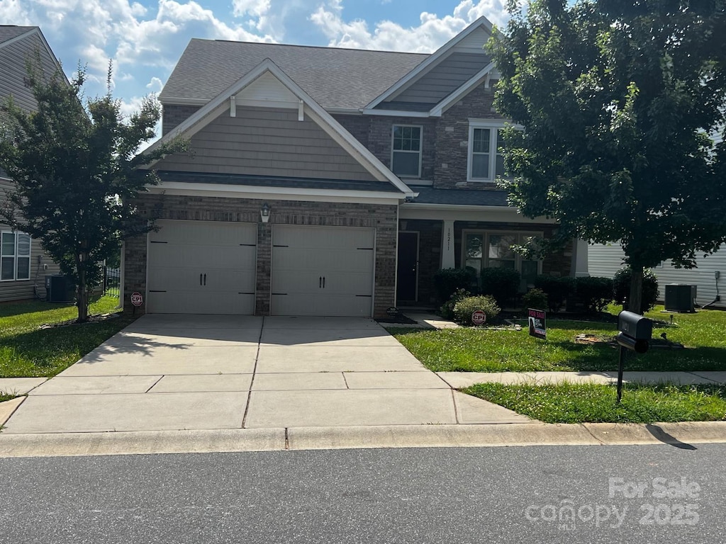 10211 Snowbell Ct, Charlotte, NC 28215 - craftsman-style house featuring driveway, stone siding, an attached garage, and a front yard