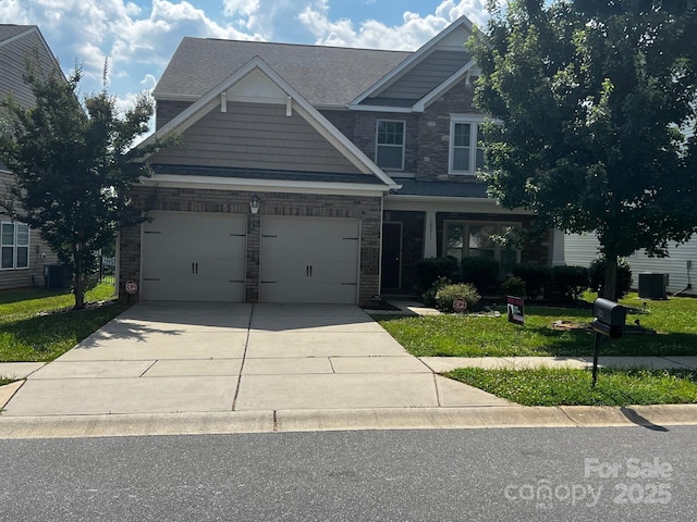 10211 Snowbell Ct, Charlotte, NC 28215 - craftsman-style house featuring driveway, stone siding, an attached garage, and a front yard