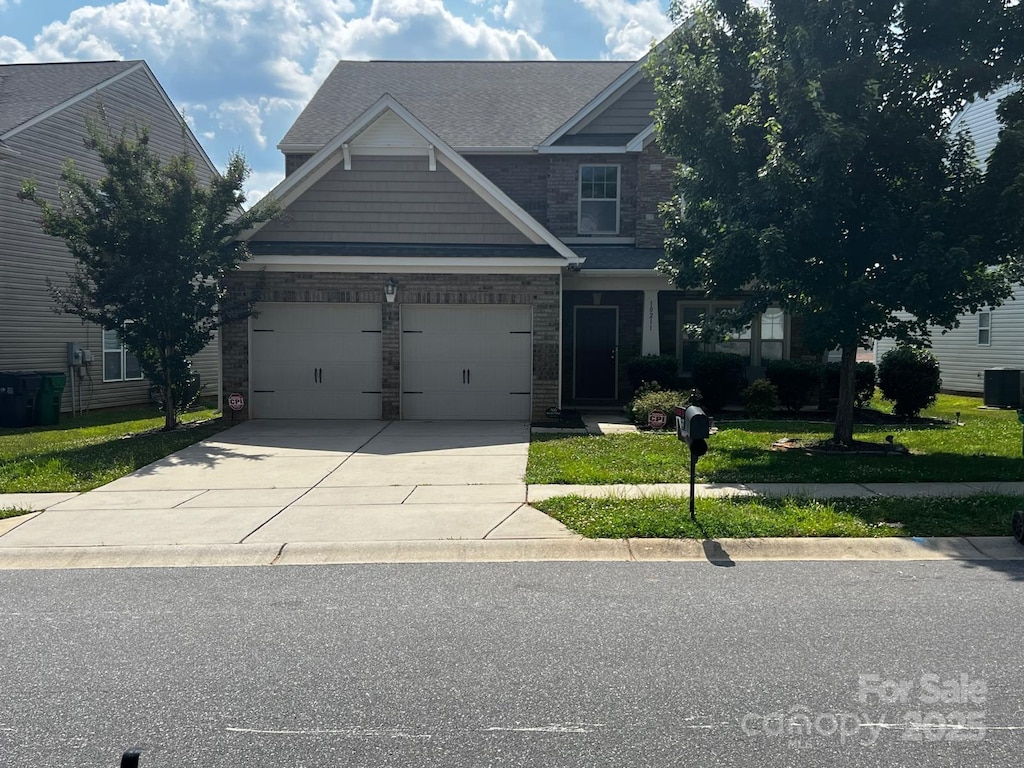 10211 Snowbell Ct, Charlotte, NC 28215 - craftsman-style home featuring driveway, a front yard, a garage, and stone siding