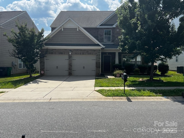 10211 Snowbell Ct, Charlotte, NC 28215 - craftsman-style home featuring driveway, a front yard, a garage, and stone siding