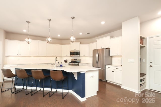 1914 Loggerhead Dr, Lancaster, SC 29720 - kitchen with appliances with stainless steel finishes, dark wood-style floors, a kitchen island with sink, white cabinets, and light countertops