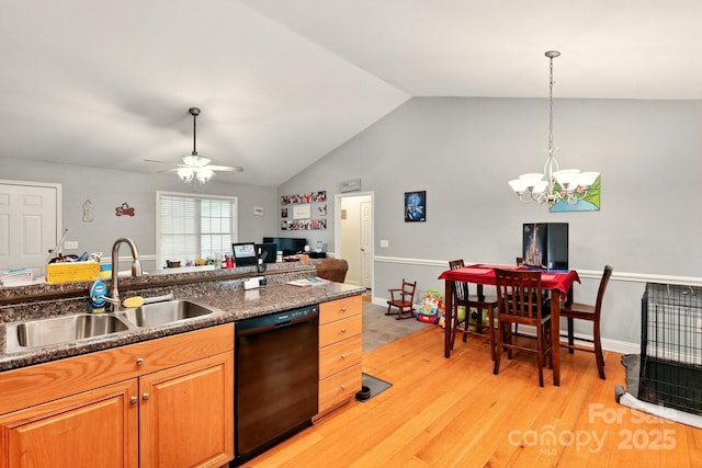 kitchen with dishwasher, a sink, dark countertops, light wood-style floors, and vaulted ceiling