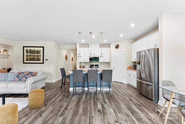 11518 Solstice Way, Huntersville, NC 28078 - kitchen with stainless steel appliances, open floor plan, wood finished floors, white cabinets, and recessed lighting