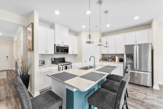 11518 Solstice Way, Huntersville, NC 28078 - kitchen featuring appliances with stainless steel finishes, a sink, tasteful backsplash, light wood-type flooring, and recessed lighting
