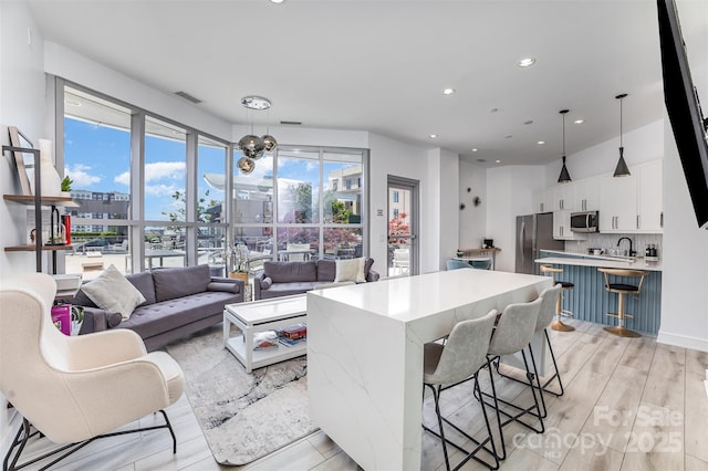 333 W Trade St Unit 1500, Charlotte, NC 28202 - living room featuring a chandelier, light wood-style floors, and recessed lighting